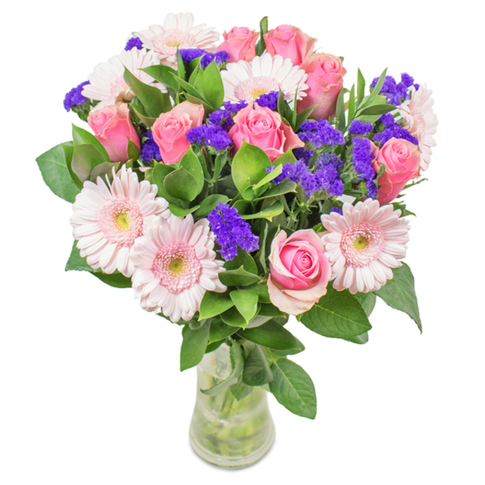 Standing proudly in a clear glass vase amid a white background, this bouquet combines floristry expertise with Canonbury's understated charm. Seven to nine pink roses, with petals elegantly furled or gently opening, form the arrangement's romantic centrepiece-each bloom radiating contemporary grace with a nod to classic beauty. Interwoven between them, five to seven pale pink gerbera daisies display their large, halo-like heads and softly blushed centres, their pastel hues suggestive of blossoms in Canonbury's private gardens. Vivid purple statice clusters, reminiscent of the lively pops of color found in local market stalls, add tactile contrast and draw the gaze deeper into the arrangement. Abundant, rich green foliage supports and frames the blooms, echoing the leafy avenues near Canonbury Crescent. Visible stems and the shimmer of fresh water in the vase evoke the authenticity for which Flower Delivery Canonbury is renowned, making it a perfect choice for birthdays, Mother's Day, anniversaries, or simply as a thoughtful gift for someone along Essex Road. This arrangement combines local knowledge, floral artistry, and a genuine sense of celebration-delivering joy and affection throughout N1.